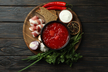 Concept of tasty food with borscht and ingredients on wooden background