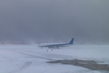 大雪の悪天候の中、離陸のタイミングを待つ旅客機