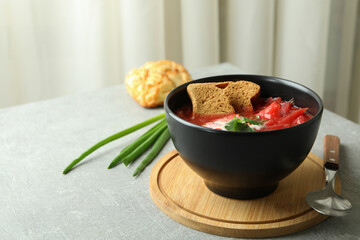 Concept of tasty eating with borscht and ingredients on gray table