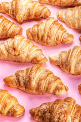 freshly baked croissants lie on a pink