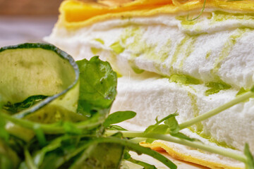 Close-up of an omelette la poulard served with green cucumber.