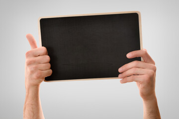 Two hands catching blackboard ok sign isolated gray background