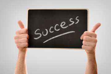 Two hands catching blackboard success message isolated gray gradient background