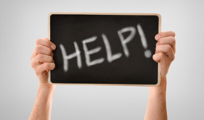 Two hands gripping fearfully blackboard with help message isolated background