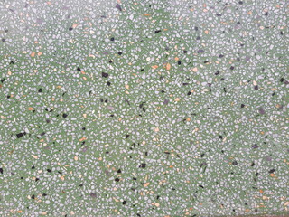Smooth polished green marble floor There are small stones lined up.