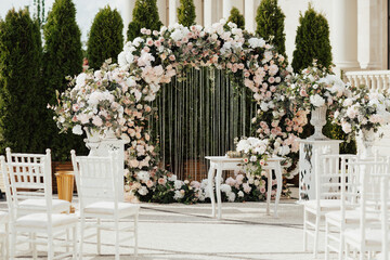 Wedding arch with white and pink roses. The arch is decorated with flowers. Wedding decor.