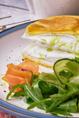 Close-up of an omelette la poulard served with green cucumber.
