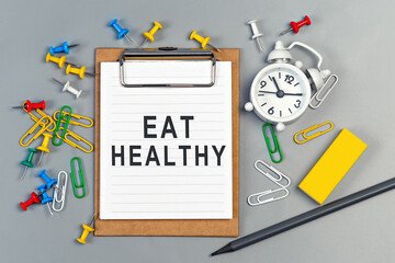 The words Eat Healthy written on a white notebook