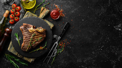Aged Beef T-Bone steak. Juicy cooked steak with rosemary and spices. Top view. Rustic style. Flat...