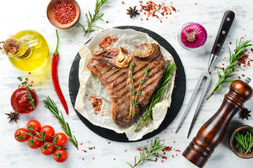 Aged Beef T-Bone steak. Juicy cooked steak with rosemary and spices. Top view. Rustic style. Flat...
