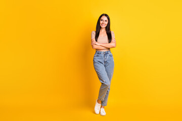 Fototapeta na wymiar Full length body size photo of curious female student folded hands smiling looking blank space isolated on vibrant yellow color background