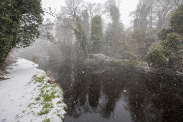 river, stream, during a snow storm, blizzard, in winter in scotland. - 413181088