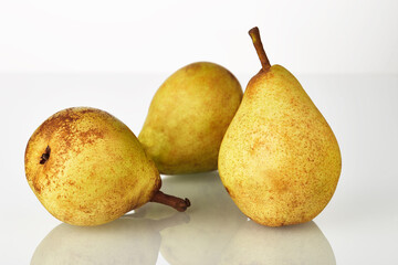 Three fresh juicy yellow-green pears fruit isolated on the white background.