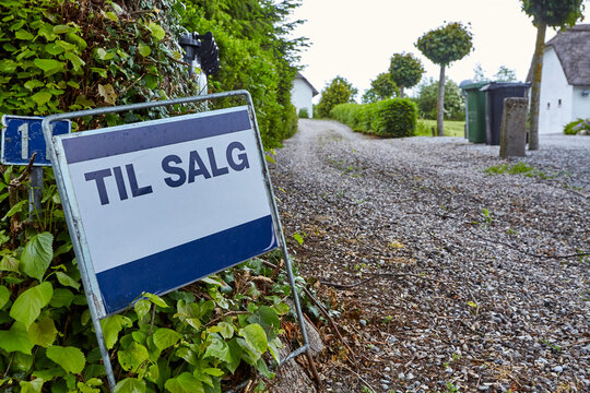 a danish for sale sign by a house