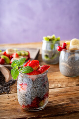 stawberry Chia pudding in glass jar wooden plank