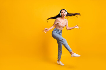 Full size photo of young happy good mood attractive lovely girl dancing in headphones isolated on yellow color background