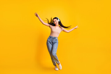 Fototapeta na wymiar Full length body size photo of dancing girl at party listening favourite song singing hit isolated on vibrant yellow color background