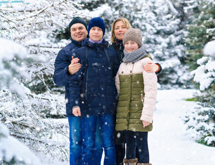 family portrait in the winter forest, parent and children, beautiful nature with bright snowy fir trees