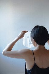 フェイスマスクをする女性の後ろ姿