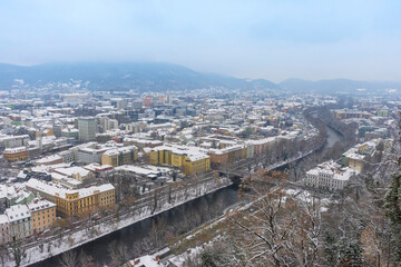 Cityscape of Graz with Mur river and historic buildings rooftops in winter with snow, in Graz, Styria region, Austria