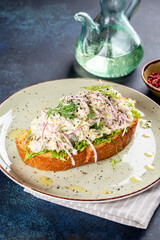 Sandwich with lingonberry and omul on a white round plate