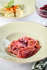 Red dumplings with cherries in a white plate filmed in decor