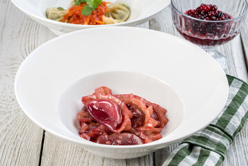 Red dumplings with cherries in a white plate filmed in decor
