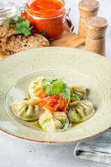 Cooked dumplings with spinach in a white plate shot from the side