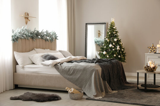 Beautiful Decorated Christmas Tree With Fairy Lights In Bedroom Interior