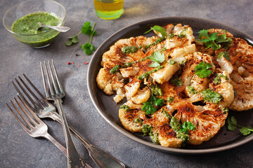 cauliflower steaks with herb sauce and spice. plant based meat substitute