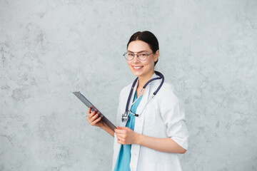 Fototapeta Young female doctor with stethoscope and folder. caucasian brunette obraz