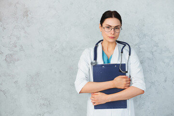 Fototapeta Young female doctor with stethoscope and folder. caucasian brunette obraz
