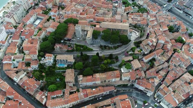 Aerial helicopter view Le Suquet the old town located in Cannes France the fortified tower and Chapel of saint Anne house the Museum de la Castre a distinctive building of Russian Orthodox church 4k