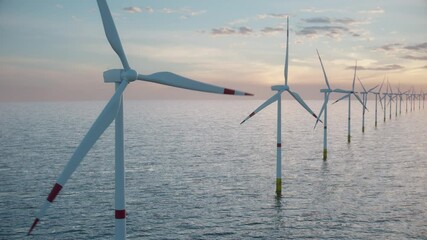 Camera pulls back to show an aerial view of a long row of offshore wind turbines in the sea against low sun. Green and renewable energy concept. Realistic high quality 3d animation.  - Powered by Adobe