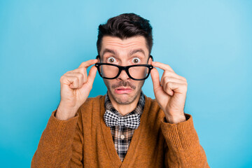 Photo of shocked amazed young man take off glasses fake news reaction isolated on blue color...