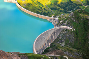 Concrete water dam high in the mountains with blue water, hydroelectric power station