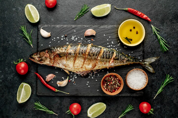 grilled mackerel with lime and spices on stone background