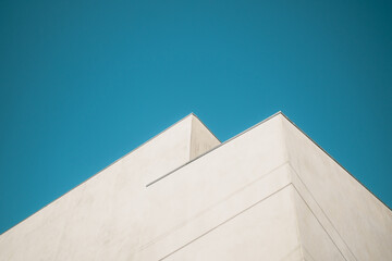 corner of modern white building against blue sky