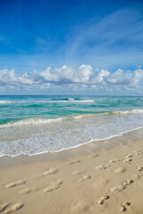 Fototapeta na wymiar Beach in Latin America. Vacation in Cuba. Green water. Aquamarine Ocean. Footprints on the beach 