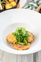 Several chickpea cutlets on a white round plate filmed in decor