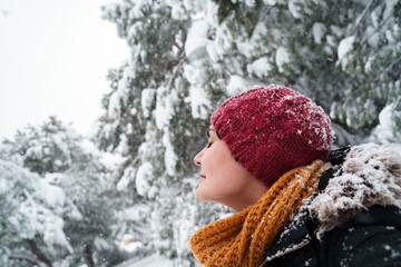 Horizontal view of young caucasian woman breathing fresh air outdoors under the snow. Environment...