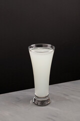 Fermented plant based alcoholic beverage in a tall glass. Selective focus, dark background, copy...