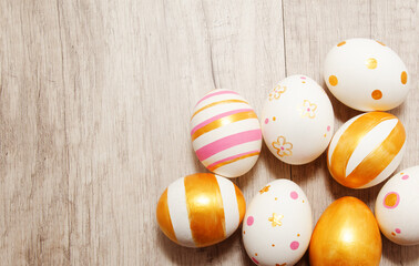 Fototapeta na wymiar Colorful golden bright handmade painted easter eggs on a wood background.