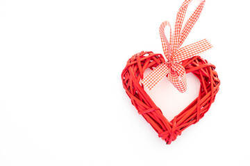 Bright red wicker heart on a solid white background © Sergei Malkov