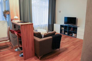 large bright living room with a bar counter and wooden floors in warm colors