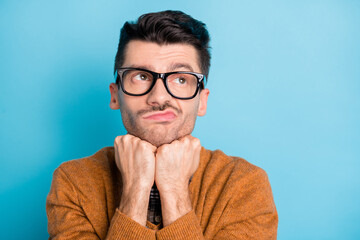 Photo of bored unhappy man look empty space hold fists chin think dream isolated on blue color...