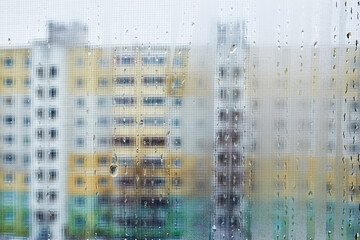 View of city houses through a fogged window