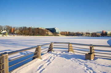 Winter frozen embankment with metal chrome railings