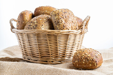 Whole wheat bread. Fresh loaf of rustic traditional bread with wheat grain ear or spike plant on linen texture background. Rye bakery with crusty loaves and crumbs. Homemade baking.