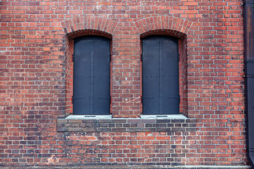 Fototapeta na wymiar 古びた赤レンガの壁と閉じた窓